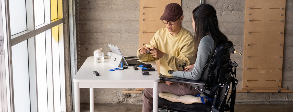 Uma mulher e um homem trabalham em conjunto com gadgets e um tablet Surface