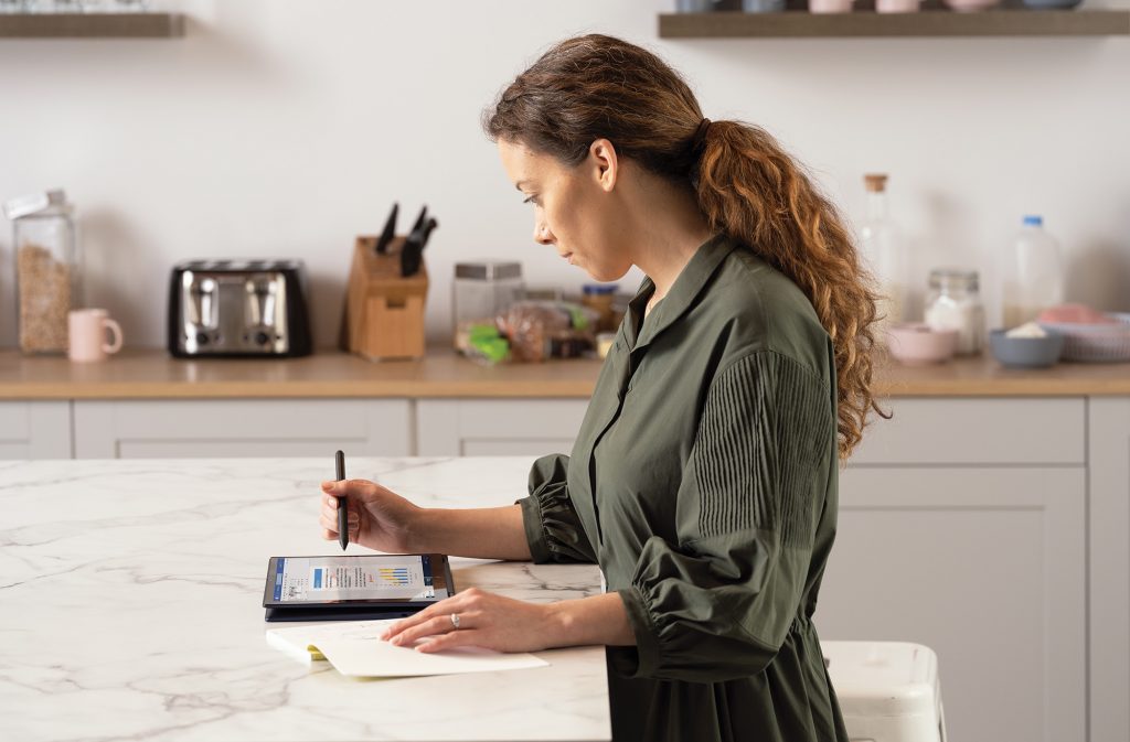 Woman uses a tablet in the kitchen